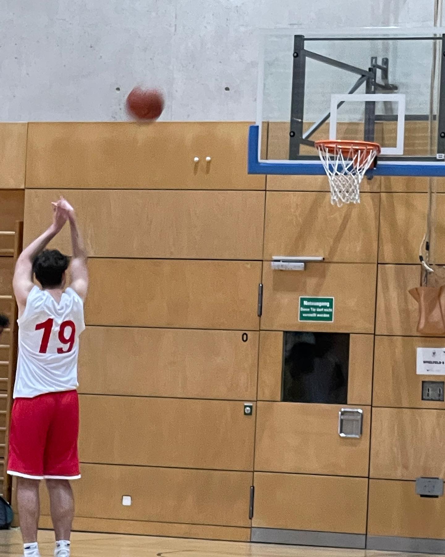 Student taking a long shot at a basketball hoop