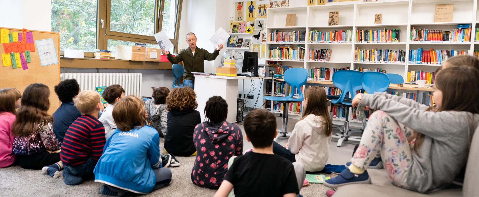 Teacher talking to a primary class in the library