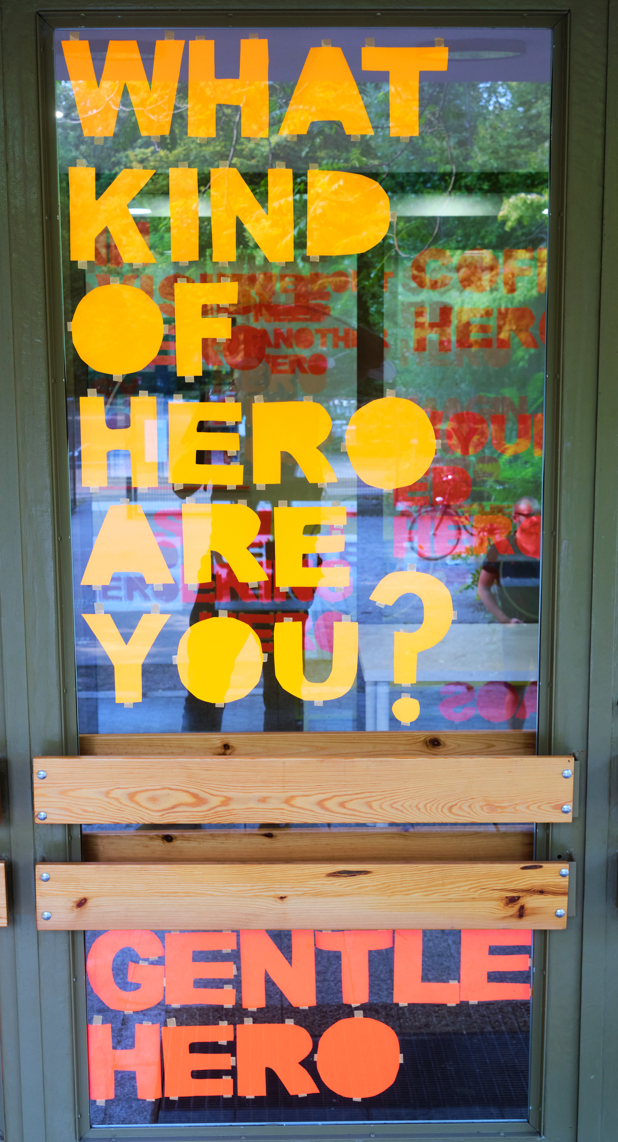 Lettering stuck to a glass door “What kind of Hero are you?”