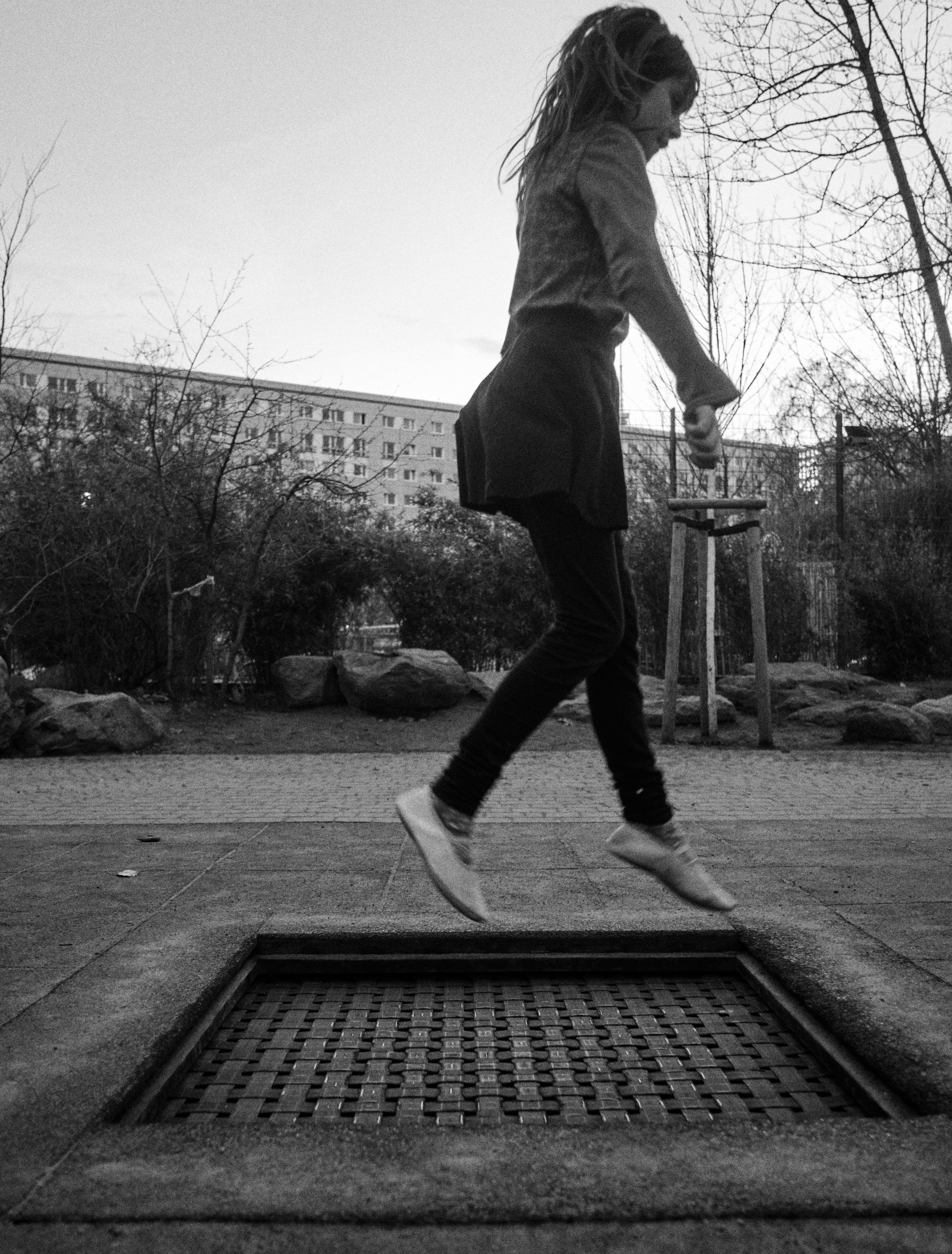 Black and White Photograph of girl on trampoline
